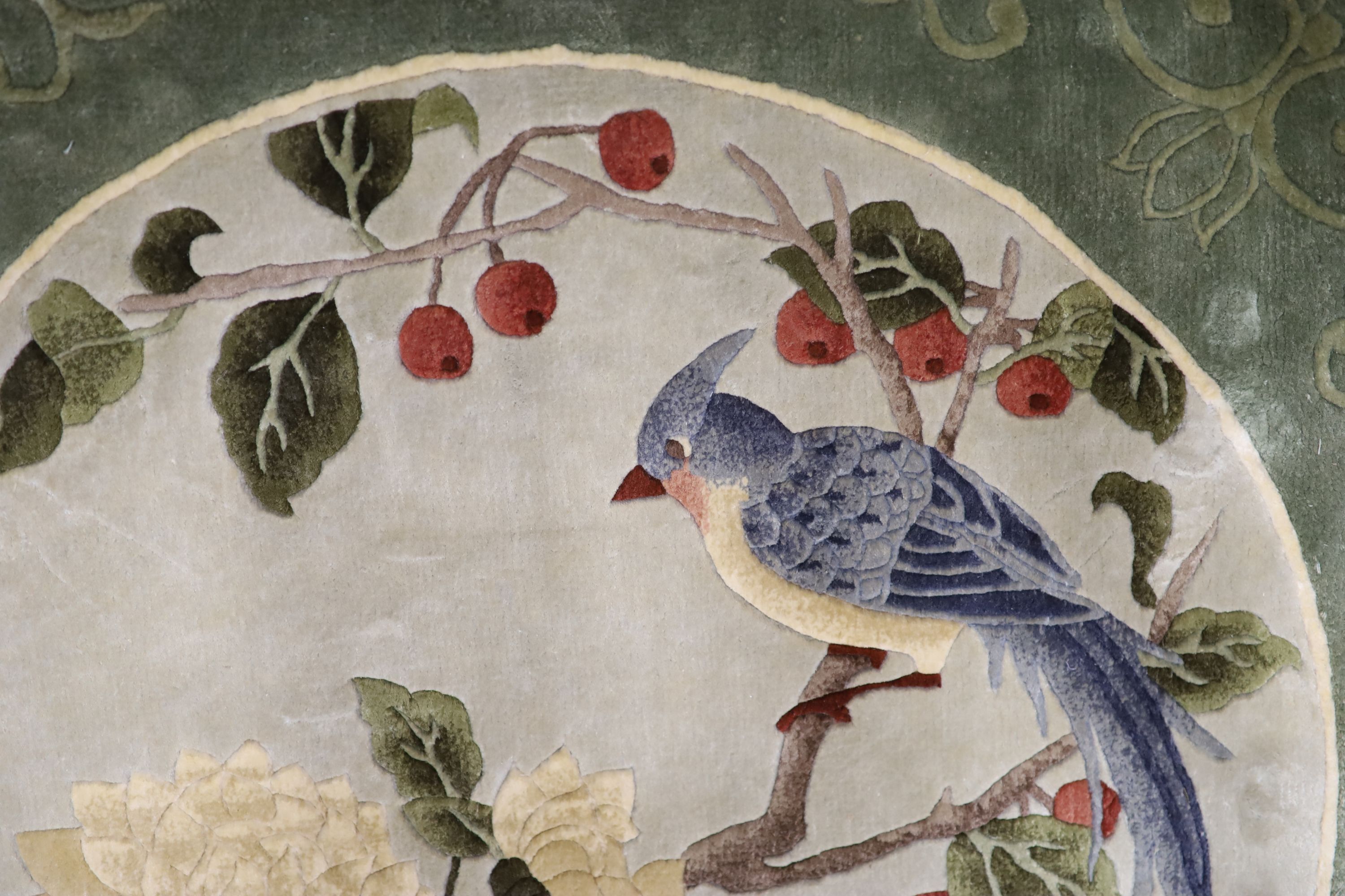 A Chinese washed and embossed panel depicting birds amongst prunus and cherries